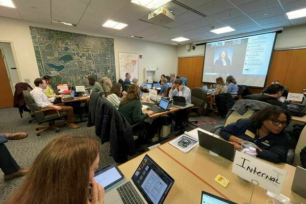 People gathered at tables during a drill for the Emergency Operations Center (EOC)