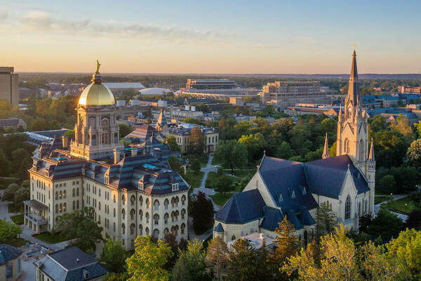 Aerial photo of campus at dawn - the Golden Dome and the Basilica of the Sacred Heart are in the foreground