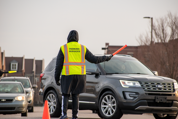 Parking Services staff member directing traffic for an athletic event